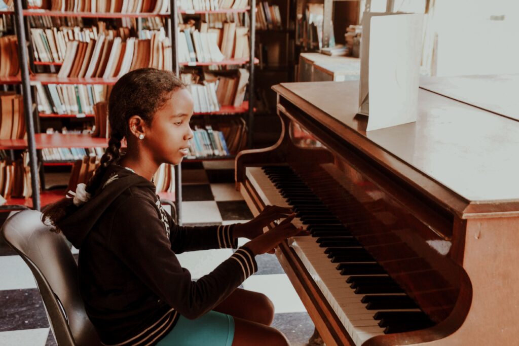 A young girl plays piano in a library, showcasing a blend of music and education.